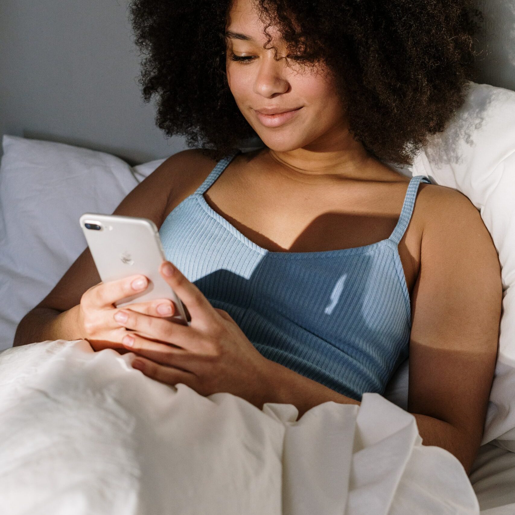 women on phone bed